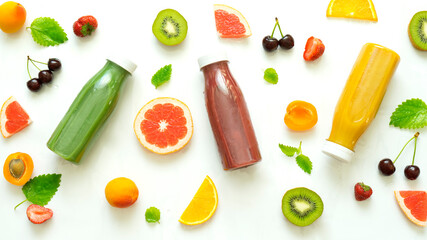 Mix of different smoothies in bottles and ripe fruits