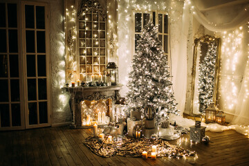 warm and cozy evening in Christmas room interior design,Xmas tree decorated by lights presents gifts,toys, deer,candles, lanterns, garland lighting indoors fireplace.holiday living room.magic New year