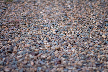 Pebbles on the beach with focus in the center of the frame and blur closer and further away