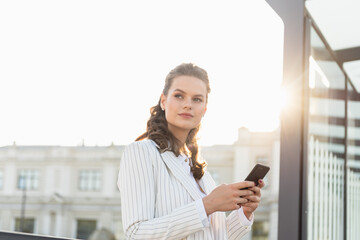 Portrait of young business woman using smartphone. Closeup shot of a businesswoman using a cellphone in the city.