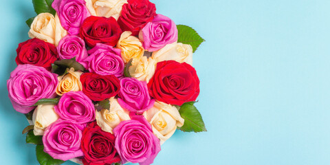 Composition of fresh multicolored roses on ceramic stand