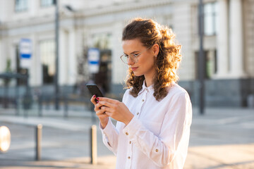 Business woman texting messages while walking. Woman with phone in subway train station. Transport app concept. Travel app.
