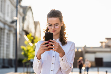 Business woman texting messages while walking. Woman with phone in subway train station. Transport app concept. Travel app.