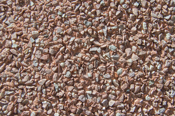background with gravel on the facade wall of a building in pink tones
