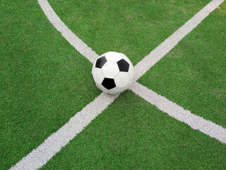 Fototapeta na wymiar Football ball over green soccer field