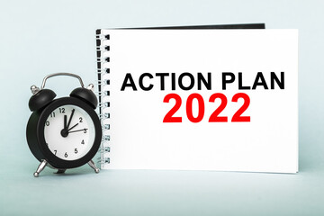 ACTION PLAN 2022, alarm clock, notebook with text , on blue background, Time running away.
