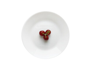 Three red cherries on a white round plate isolated on a white background. Top view