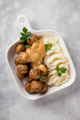 Traditional swedish meatballs with creamy sauce and mashed potatoes on gray table close up vertical photo