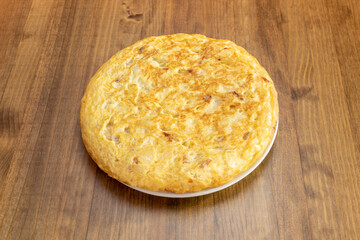 Spanish potato omelette with farm chicken eggs and onion on wooden table