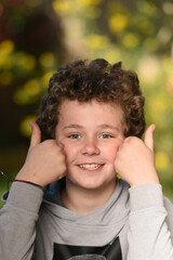 young child in a park on a background of green foliage