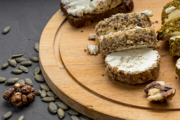 sliced white soft cheese on a wooden board and pumpkin seeds