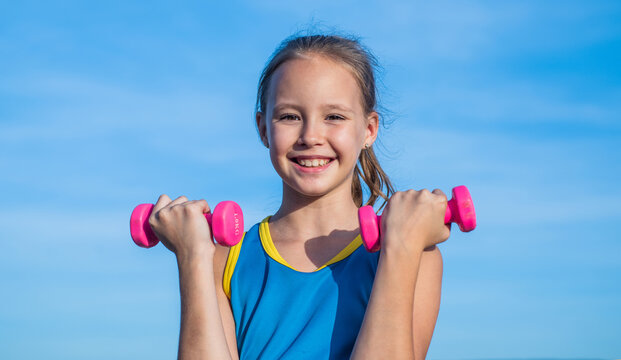 workout outdoor. teen girl use dumbbell. sporty kid in sportswear do lifting exercise.