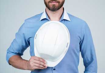 Unshaven man engineer cropped view hold hardhat protective helmet blue background, safety
