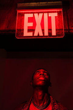 Man looking up on sign in neon light