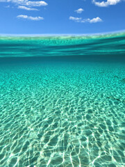 Split underwater photo of exotic island paradise bay with crystal clear emerald sandy beach