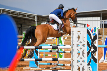 Rider on horse jumping over a hurdle during the equestrian event	
