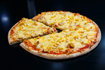 Delicious Italian pizza with raw meat, tomatoes and olive oil on a dark concrete table. Top view with copy space.