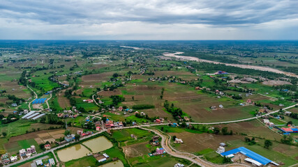 Fototapeta na wymiar Aerial shot of houses scattered across a large farmland in the countryside Nepal.
