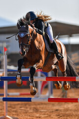 Rider on horse jumping over a hurdle during the equestrian event	
