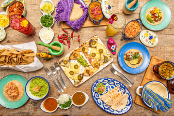 Set of plates and tableware of popular Mexican food. Synchronized quesadillas, Tinga tacos, corn...