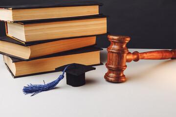 Judge's gavel and graduation cap with books on the table