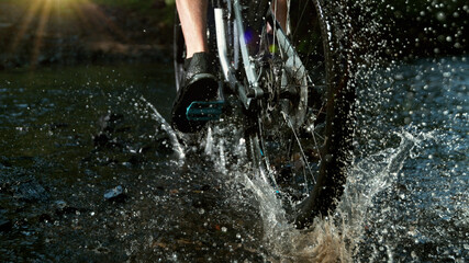 Close-up of mountain rider splashing water in river