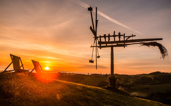 sunrise next to a traditional wooden windmill (in german Klapotetz) on the wine yards of southern Styria in Austria