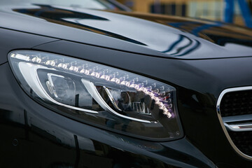 Obraz na płótnie Canvas Headlight of a modern luxury car, auto detail,car care concept