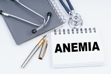 On the table are a stethoscope, a pen and a notebook with the inscription - ANEMIA