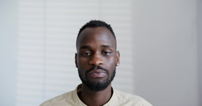 black guy with a beard is seriously looking at the camera close-up