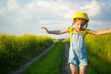 Cheerful girl in a yellow hat in a summer field laughs and smiles. Joy, sunny weather, holidays. A remedy for mosquitoes and insects. Lifestyle, kind face, close-up portrait, enjoying freedom