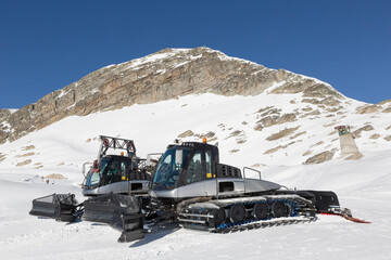 Pair of snow cats on the ski slopes in the high mountains
