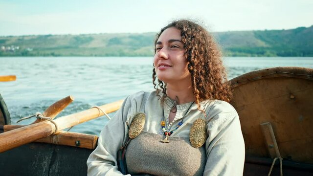 A Viking Woman Sits on Board the Drrakar. Vikings Sail on an Old Ship