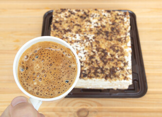 Closeup shot of a cup of coffee of a tasty cake background