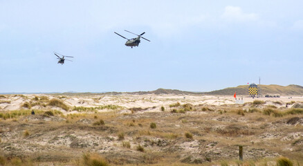 Fototapeta na wymiar Chinook helicopters flying over the dunes