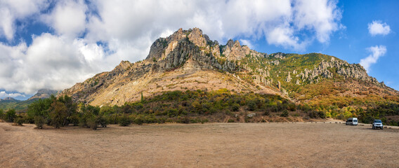 Beautiful scenic sunny blue sky with clouds landscape of Yuzhnaya Demerdzhi rocky mountain in Crimea, Russia called Dolina Privideniy, or Ghost Valley. Wide angle panorama of Demerdji mountain. © Wilding