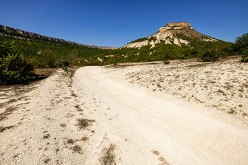 Tepe-Kermen is an ancient cave town in Crimea. Scenic sunny day landscape.