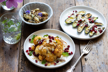Vegan dishes of miso aubergine, roasted cauliflower and baby courgettes