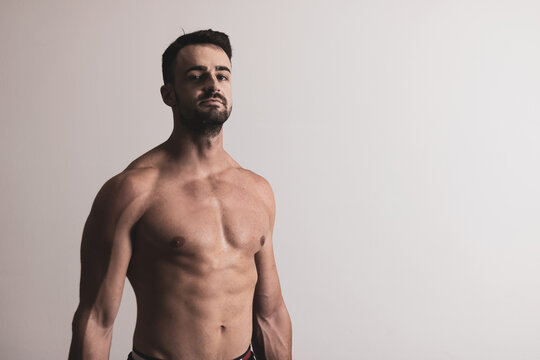a handsome and muscular guy posing on a white background