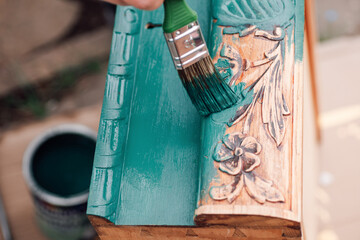 the process of painting a wooden dresser drawer or table with a floral pattern outdoors, an...