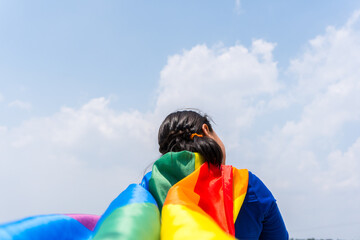 Closeup shot of a small girl with a rainbow flag