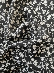 Transparent fabric with small white flowers on a black background.