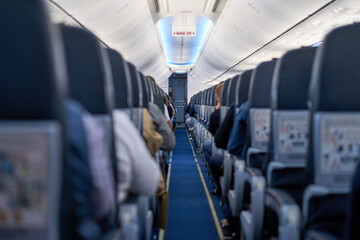 Interior of a passenger plane, passage between the seats.