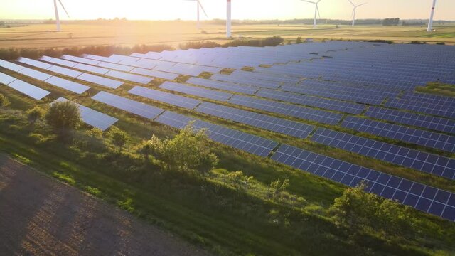Windkraftanlage mit Solarpark bei Sonnenuntergang im Sommer