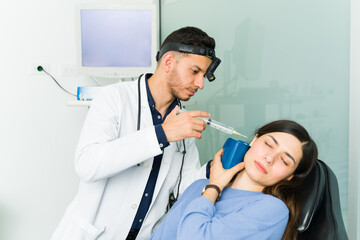 Hispanic doctor doing an ear irrigation