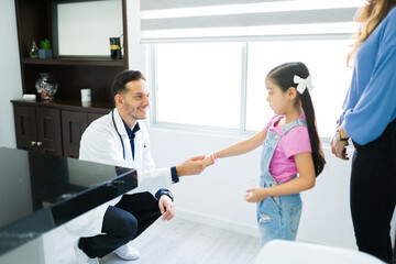 Smiling physician greeting a kid patient