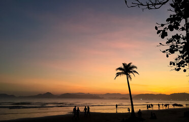 Late afternoon in the city of Santos, Brazil, with tourists walking on the beach
