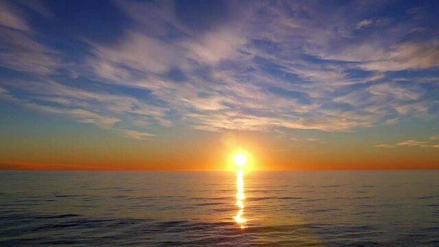 The reflection of the sunrise on the sea in the early morning and the rippling sea surface, time-lapse