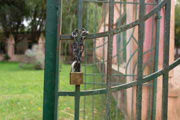 Rusty gate with a chain and a padlock.