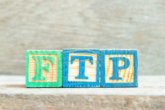 Color alphabet letter block in word FTP (Abbreviation of File Transfer Protocol) on wood background